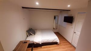 Dormitorio pequeño con cama y mesa en Apartaestudios Amoblados Galerías, en Bogotá