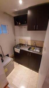 uma pequena cozinha com um lavatório e um fogão em Apartaestudios Amoblados Galerías em Bogotá
