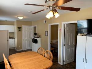 a kitchen and dining room with a table and a ceiling fan at Wu Wu's Cabins in Wasaga Beach