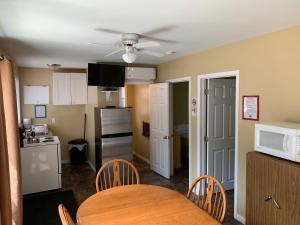 a kitchen with a table and chairs and a microwave at Wu Wu's Cabins in Wasaga Beach