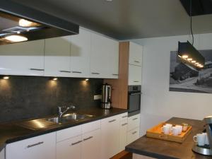 una cocina con armarios blancos y fregadero en Bedecked Holiday Home in Vielsalm with Sauna, en Vielsalm