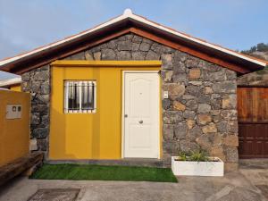 伊科德德洛斯維諾斯的住宿－Casa Nido，一间黄色和白色门的小房子