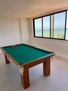 una mesa de billar en una habitación con vistas al océano en Apartamento Praia de Carapibus, en Conde