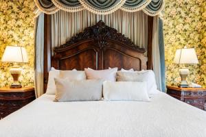 um quarto com uma cama grande e almofadas brancas em The Inn at Erlowest em Lake George