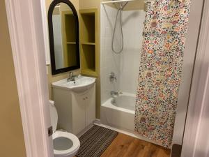 a bathroom with a toilet and a sink and a shower at Wu Wu's Cabins in Wasaga Beach