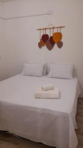 een wit bed met witte lakens en handdoeken erop bij Quarto Dani in Jericoacoara