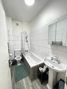 ein Badezimmer mit einer Badewanne, einem Waschbecken und einem WC in der Unterkunft King's Cross in London