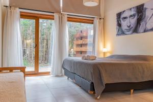 1 dormitorio con cama y ventana grande en Los Amancays 2 en Villa La Angostura