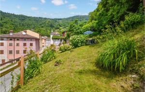 a green hillside with houses and a fence at Nice Home In Lusiana With Kitchen in Lusiana