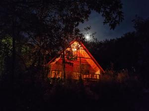 a barn lit up at night with the moon behind it at Chalé do Mirante do Itacolomi in Ouro Preto
