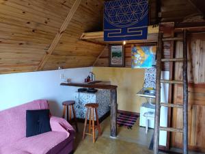 a living room with a couch and a bar at Chalé do Mirante do Itacolomi in Ouro Preto