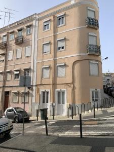 un edificio en una calle con coches aparcados delante en Lisboa - Arroios Central Apartment en Lisboa