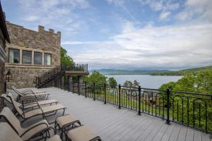 a balcony with chairs and a view of a lake at The Inn at Erlowest in Lake George