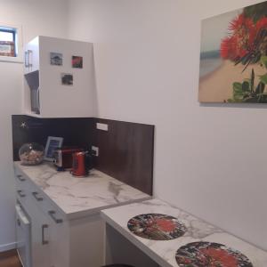 a kitchen with a counter with two plates on it at Papamoa Beach Hugoway, Pohutukawa Studio Deluxe, Close beach, free parking in Papamoa