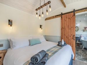 um quarto com uma cama e uma casa de banho com uma banheira em The Liddel Dutch Barn - Uk44465 em Saughtree