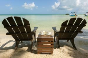 2 sillas y una mesa en la playa en Beachfront Hotel La Palapa - Adults Only, en Isla Holbox
