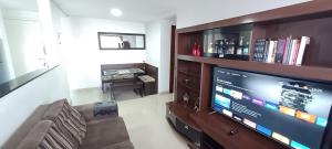 uma sala de estar com uma grande televisão de ecrã plano em Apê UNIFA-EsSLog Condomínio com estacionamento no Rio de Janeiro