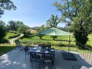 a table with chairs and an umbrella on a patio at Gîte Marcillat-en-Combraille, 3 pièces, 6 personnes - FR-1-489-369 in Marcillat-en-Combraille