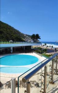 - Balcón con vistas a la piscina y a la playa en Apartamento em Frente ao Mar, en Río de Janeiro