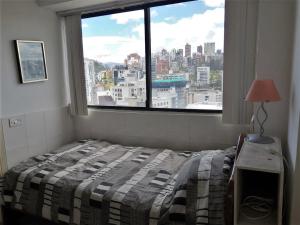 a bedroom with a bed and a large window at Apartment in Quito (La Carolina) in Quito