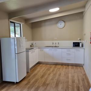 a kitchen with a refrigerator and a clock on the wall at Robe Holiday Park in Robe