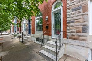 a brick building with stairs on a street at Pristine Townhouse With Rooftop Deck Near Canton! in Baltimore