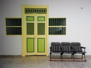 due panche sedute davanti a una porta gialla di Hostal El fin del afán a Jericó