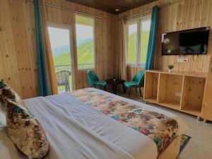 a bedroom with a bed and a television and windows at Nature Heaven Lodge, Mussoorie in Mussoorie