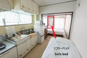 a small kitchen with a sink and a bed at COCOSTAY Felice ココステイ フェリーチェ in Hiroshima