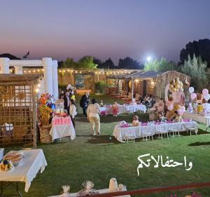 a group of people sitting at tables at a party at اسطبلات أساور للفروسية Asawer Equestrian Stables 