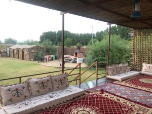 a patio with a bed and pillows on a deck at اسطبلات أساور للفروسية Asawer Equestrian Stables 
