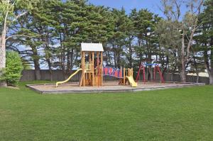 um parque infantil com escorrega num parque em Gum Tree Caravan Park em Port Fairy