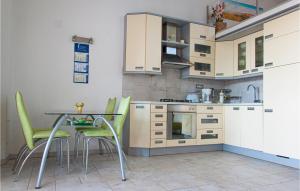 a kitchen with a table and some green chairs at 2 Bedroom Nice Home In Sveti Ivan in Sveti Ivan