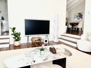 a living room with a tv and a table at Luxury in dress circle location 