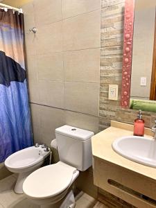 a bathroom with a toilet and a sink at Kimbara Bosque y Mar in Mar de las Pampas