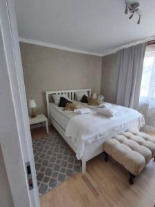 a bedroom with a large white bed and a window at Brook-Stone Beach Guesthouse in Sztutowo
