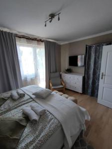 a bedroom with a large bed and a window at Brook-Stone Beach Guesthouse in Sztutowo