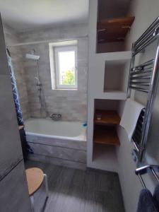 a bathroom with a bath tub and a window at Brook-Stone Beach Guesthouse in Sztutowo