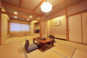 uma sala de estar com uma mesa e cadeiras e uma janela em Hakuba Onsen Ryokan Shirouma-so em Hakuba
