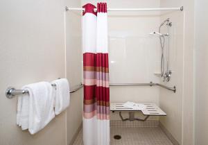 a bathroom with a shower curtain and a bench at Red Roof Inn Philadelphia - Oxford Valley in Langhorne