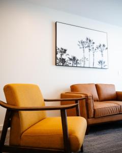 Peninsula Hotel Motel في أديلايد: غرفة بها كرسي وطاولة وأريكة