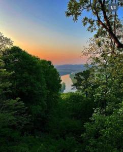 a view of a lake through the trees at sunset at White River Mountain Manor- Million dollar view in Eureka Springs
