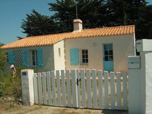 uma pequena casa branca com uma cerca branca em Maison Noirmoutier-en-l'Île, 4 pièces, 6 personnes - FR-1-224B-201 em Noirmoutier-en-l'lle