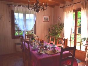 una sala da pranzo con tavolo e tovaglia rosa di Séjour bucolique en Sologne avec chambres confortables dans maison accueillante - FR-1-590-359 a Vannes-sur-Cosson