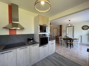uma cozinha com armários brancos e uma sala de jantar em Gîte Saligny-sur-Roudon, 3 pièces, 5 personnes - FR-1-489-461 em Saligny-sur-Roudon