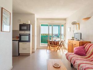 ein Wohnzimmer mit einem Sofa und eine Küche mit einem Tisch in der Unterkunft Appartement Anglet, 2 pièces, 4 personnes - FR-1-3-592 in Anglet