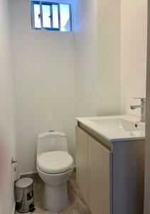 a white bathroom with a toilet and a sink at Apartamento con Excelente Ubicación en Envigado in Envigado