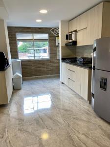 a large kitchen with a stainless steel refrigerator at Apartamento con Excelente Ubicación en Envigado in Envigado