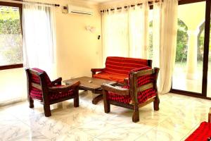 a living room with two chairs and a table at Romantic Mediterranean beach house in Dar es Salaam