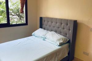 a bed with a headboard and two pillows on it at Romantic Mediterranean beach house in Dar es Salaam